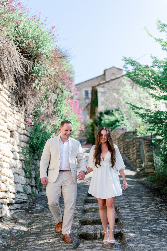 Couple walking hand in hand through Gordes' narrow streets